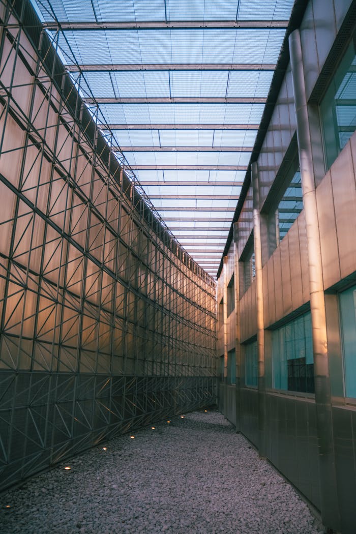 creative A narrow modern hallway with steel and glass architecture, showcasing elegant structural design.